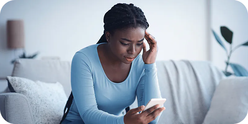 Mulher preocupada olhando para o celular, ilustrando a espera após a expedição de ofício no processo de precatório