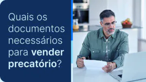 Homem analisando papéis e seu computador, ponderando sobre vender precatório