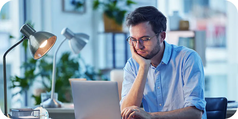 Homem sentado fazendo uma pesquisa em seu notebook, ilustrando como consultar precatório