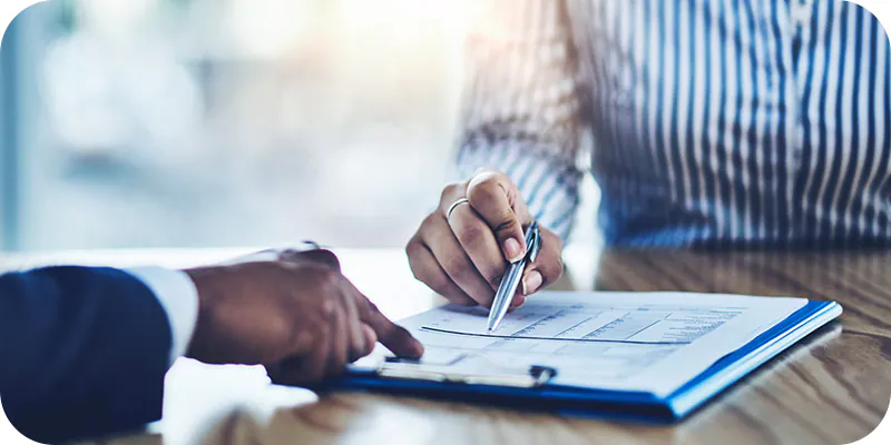 mão segurando caneta sobre documento, ilustrando a analise da porcentagem de valor incontroverso e controverso de um precatório