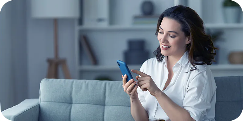 Mulher sorrindo ao usar seu celular, ilustrando oferta de antecipação de precatório
