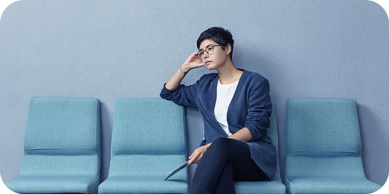 Mulher sentada aguardando, ilustrando a espera na fila de seu precatório de Santo André