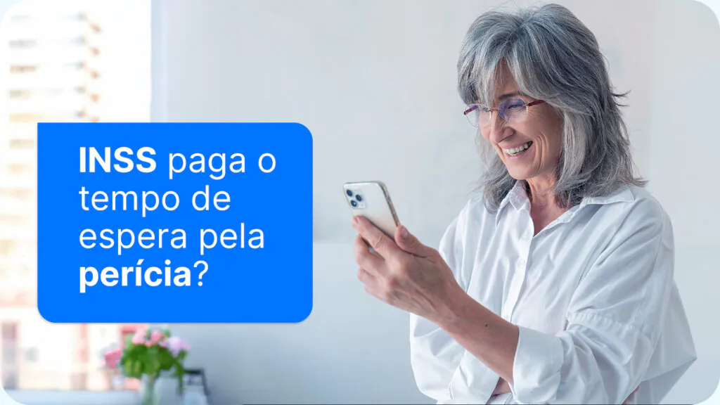 Mulher idosa usando o celular, conferindo se o INSS paga o tempo de espera pela perícia