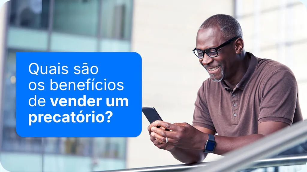 Homem sorridente usando celular para pesquisar sobre os benefícios de vender um precatório